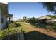 Large backyard with a grassy area, hedges, and mature trees at 2451 E Del Webb Blvd, Sun City Center, FL 33573