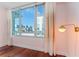 Bright bedroom with hardwood floors, large window with city view and soft pink walls at 912 Channelside Dr # 2607, Tampa, FL 33602