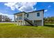 Modern house exterior with a balcony, stairs, and a grassy lawn at 2316 S 46Th St, Tampa, FL 33619