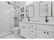Modern bathroom with white cabinets, double vanity, and marble shower at 2316 S 46Th St, Tampa, FL 33619