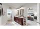 Spa-like bathroom with double vanity and a view into the main bedroom at 2616 Garden Plum Pl, Odessa, FL 33556