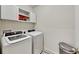 Convenient laundry room with washer, dryer, and overhead cabinets at 2616 Garden Plum Pl, Odessa, FL 33556