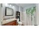 Clean bathroom with tub shower combo, vanity, and linen storage at 2616 Garden Plum Pl, Odessa, FL 33556