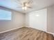 Bedroom with wood-look floors, ceiling fan, and double sliding door closet at 1709 E Sitka St, Tampa, FL 33604