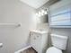 Bathroom featuring a toilet, vanity, and window with blinds at 1709 E Sitka St, Tampa, FL 33604