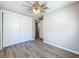 Bedroom with wood-look floors, ceiling fan, and double sliding door closet at 1709 E Sitka St, Tampa, FL 33604