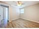 Bright bedroom with wood-look floors, ceiling fan, and access to another room at 1709 E Sitka St, Tampa, FL 33604