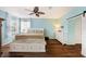 Bedroom with light blue walls, hardwood floors, and a white platform bed at 5806 Candytuft Place, Land O Lakes, FL 34639