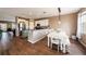 Open concept kitchen and dining area with wood flooring and white cabinetry at 5806 Candytuft Place, Land O Lakes, FL 34639