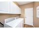 Laundry room with white cabinets and washer and dryer at 5806 Candytuft Place, Land O Lakes, FL 34639