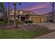 Two-story house with a three-car garage and landscaping at dusk at 5806 Candytuft Place, Land O Lakes, FL 34639