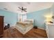 Main bedroom with light blue walls, ceiling fan, and wood flooring at 5806 Candytuft Place, Land O Lakes, FL 34639