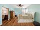 Main bedroom with light blue walls, a large bed, and access to another room at 5806 Candytuft Place, Land O Lakes, FL 34639