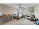 Bright bedroom with a crib, dresser, and comfy armchair at 19065 Malinche Loop, Spring Hill, FL 34610