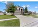 Two-story house with gray siding, stone accents, and a three-car garage at 19065 Malinche Loop, Spring Hill, FL 34610