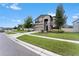 Two-story house with gray siding, stone accents, and a three car garage at 19065 Malinche Loop, Spring Hill, FL 34610