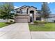 Two-story house with gray siding, stone accents, and a three car garage at 19065 Malinche Loop, Spring Hill, FL 34610
