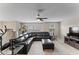 Relaxing living room with sectional sofa, large TV, and ceiling fan at 19065 Malinche Loop, Spring Hill, FL 34610