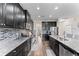 Modern kitchen with dark cabinetry, granite countertops, and stainless steel appliances at 19065 Malinche Loop, Spring Hill, FL 34610