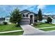 Two-story house with gray siding, stone accents, and a three car garage at 19065 Malinche Loop, Spring Hill, FL 34610