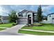 Two-story house with gray siding, stone accents, and a three-car garage at 19065 Malinche Loop, Spring Hill, FL 34610