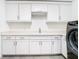 Well-appointed laundry room with white cabinets and countertop at 920 N Osceola Ave # 703, Clearwater, FL 33755