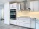 Modern kitchen with double oven, stainless steel appliances, and white cabinets at 920 N Osceola Ave # 703, Clearwater, FL 33755