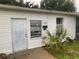 Front view of a white single story home with overgrown landscaping at 1908 51St W Ave, Bradenton, FL 34207