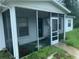 Screened front porch with damaged screen and overgrown yard at 1908 51St W Ave, Bradenton, FL 34207