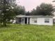 White single story home with screened porch and overgrown yard at 1908 51St W Ave, Bradenton, FL 34207