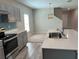 Modern kitchen with gray cabinets, quartz countertops and island at 13116 Shumard Way, Riverview, FL 33579