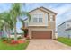 Two-story house with a brown garage door and palm trees in the front yard at 11818 Lake Blvd, New Port Richey, FL 34655