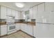 Bright kitchen with white cabinets, appliances, and light brown countertops at 6824 N Sterling Ave, Tampa, FL 33614