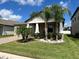 Tan house with beige garage door, landscaping, and palm trees at 13240 Satin Lily Dr, Riverview, FL 33579