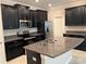 Kitchen with dark cabinetry, granite countertops, and island at 13240 Satin Lily Dr, Riverview, FL 33579