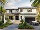 Stunning two-story home featuring a metal roof, an attached garage, and a meticulously landscaped front yard at 559 W Davis Blvd, Tampa, FL 33606