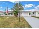 White Ranch house with American flag and palm tree at 9820 44Th N Way, Pinellas Park, FL 33782