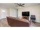 Bright living room featuring hardwood floors, a comfy couch, and a large TV at 4084 Bruing St, North Port, FL 34286