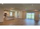 Bright, open-concept living area with wood floors, recessed lighting, island, and sliding glass doors at 10736 Tippecanoe Pl, Parrish, FL 34219