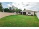 Expansive backyard with lush green grass, privacy wall, and partial view of screened in lanai at 11892 Frost Aster Dr, Riverview, FL 33579