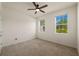 Empty bedroom showcasing carpeted floors, neutral walls, and two windows providing ample natural light at 11892 Frost Aster Dr, Riverview, FL 33579