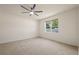 Bright bedroom featuring a neutral carpet, a ceiling fan, and a large window with a view of the backyard at 11892 Frost Aster Dr, Riverview, FL 33579