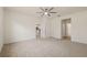 Spacious main bedroom featuring a neutral carpet, a ceiling fan, and doorways to the en suite and hallway at 11892 Frost Aster Dr, Riverview, FL 33579