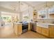 Modern kitchen featuring stainless steel appliances, light wood cabinetry, and a view into the living room at 440 22Nd N St, St Petersburg, FL 33713