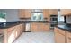 Modern kitchen with light wood cabinets, stainless steel appliances, and dark countertops at 18141 Sandy Pointe Dr, Tampa, FL 33647