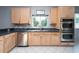 Modern kitchen with light wood cabinets, stainless steel appliances, and dark countertops at 18141 Sandy Pointe Dr, Tampa, FL 33647