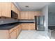 Modern kitchen with light wood cabinets, stainless steel appliances, and dark countertops at 18141 Sandy Pointe Dr, Tampa, FL 33647