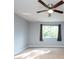 Spacious bedroom with ceiling fan and large window with gray curtains at 18141 Sandy Pointe Dr, Tampa, FL 33647