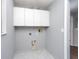 Functional laundry room with upper cabinets and built-in shelving at 18141 Sandy Pointe Dr, Tampa, FL 33647