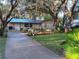 Landscaped front yard with mature trees and a long driveway at 5612 Kenny Dr, Tampa, FL 33617